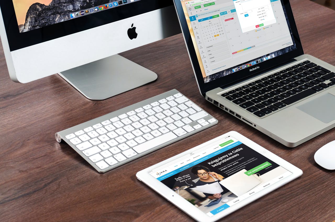 about-us-01 A sleek office desk setup featuring Apple devices: iMac, MacBook, and iPad.